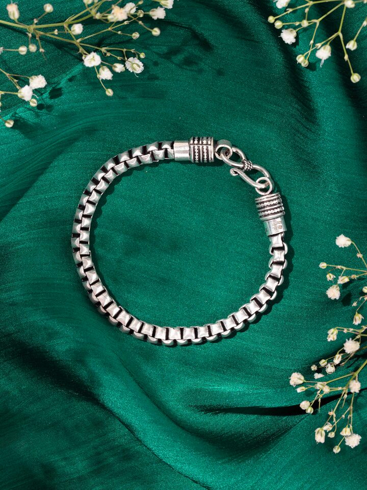 Lifestyle view of men’s silver bracelet worn on wrist to show rugged elegance