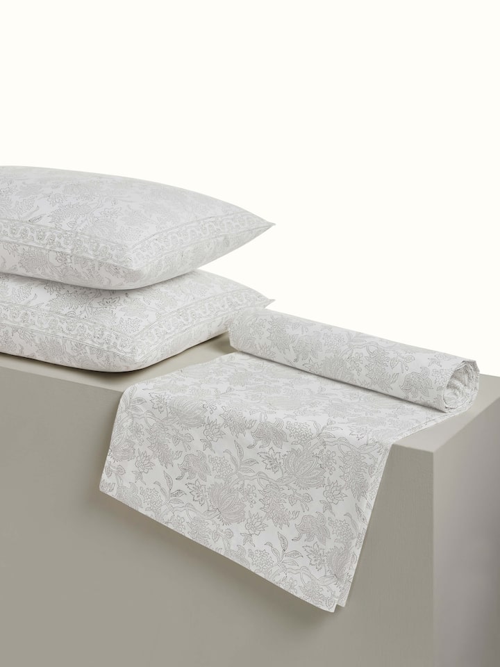 Angled view of grey floral Sanganeri cotton bedsheet showcasing full bedspread layout