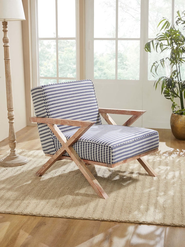 Side view of Swadesh Upholstered Acacia Wood Armchair highlighting its smooth wooden legs and stylish armrest design
