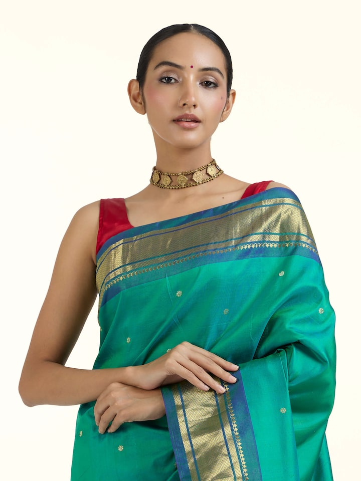 Angled view of green silk Paithani saree emphasizing woven patterns and silk sheen