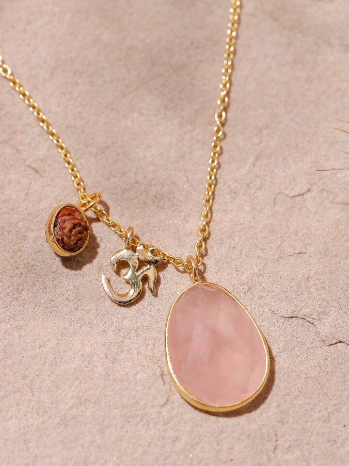 Angled view of Rudraksha, Om Charm & Rose Quartz Necklace focusing on the alignment of elements and spiritual symbolism