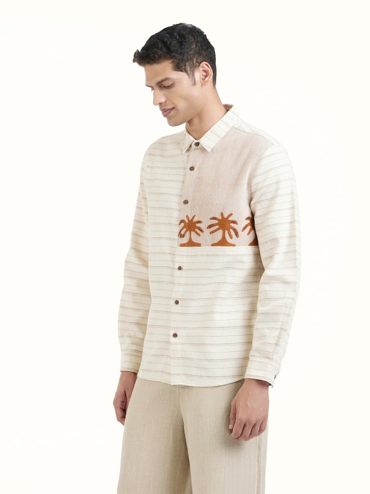 Angled view of Ivory Kutchi Embroidered Shirt revealing the depth of its color and intricate pattern
