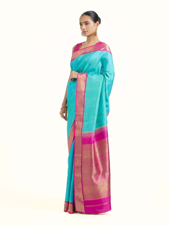 Side view of turquoise silk Kancheepuram saree highlighting graceful drape and border