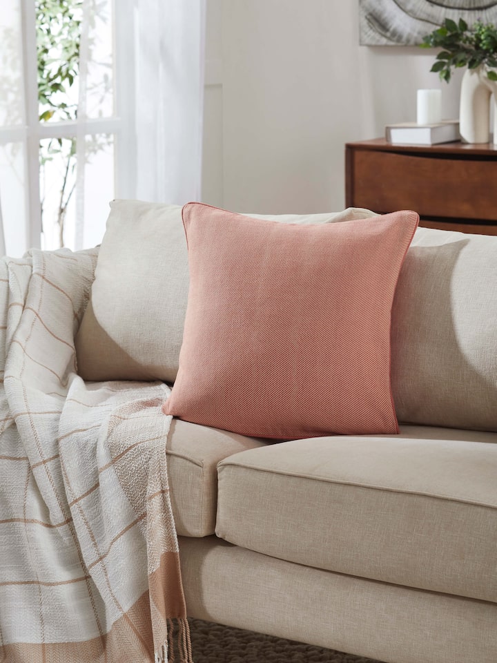 Side view of Godna Peach Diamond Cotton Handwoven Pattu Cushion Cover highlighting the detailed weave and textured finish