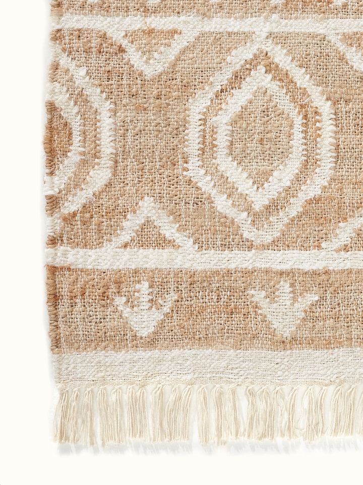 Angle view of Graphic Geo Beige Jute Natural Fibre Rug highlighting the texture and pattern from a side perspective.