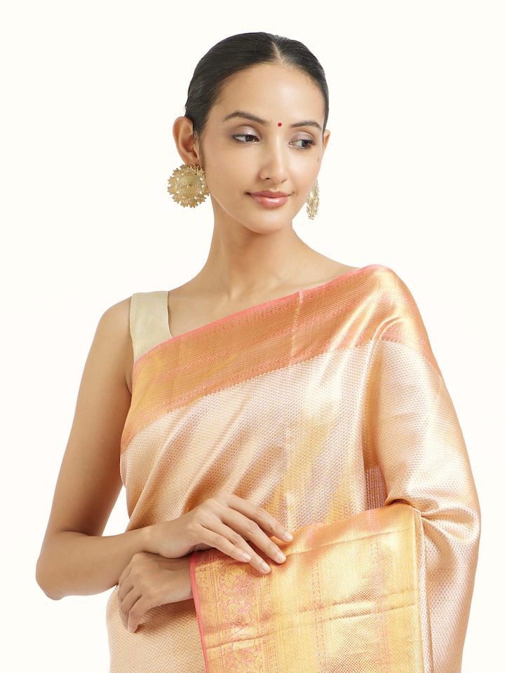 Angled view of beige silk Kancheepuram saree highlighting traditional weave