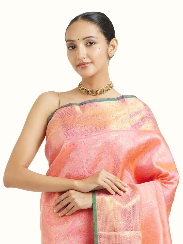 Angled view of pink silk Kancheepuram saree highlighting traditional weave and sheen