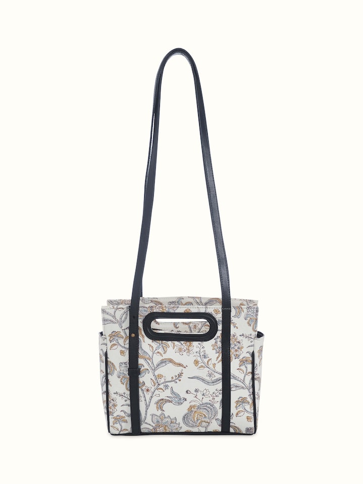 Front view of black leather and textile sling bag with hand block prints.