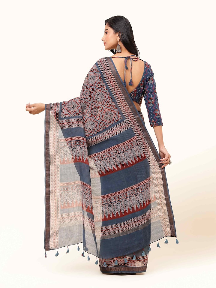 Back view of blue Maheshwari Ajrakh block printed saree displaying pleats and border design.