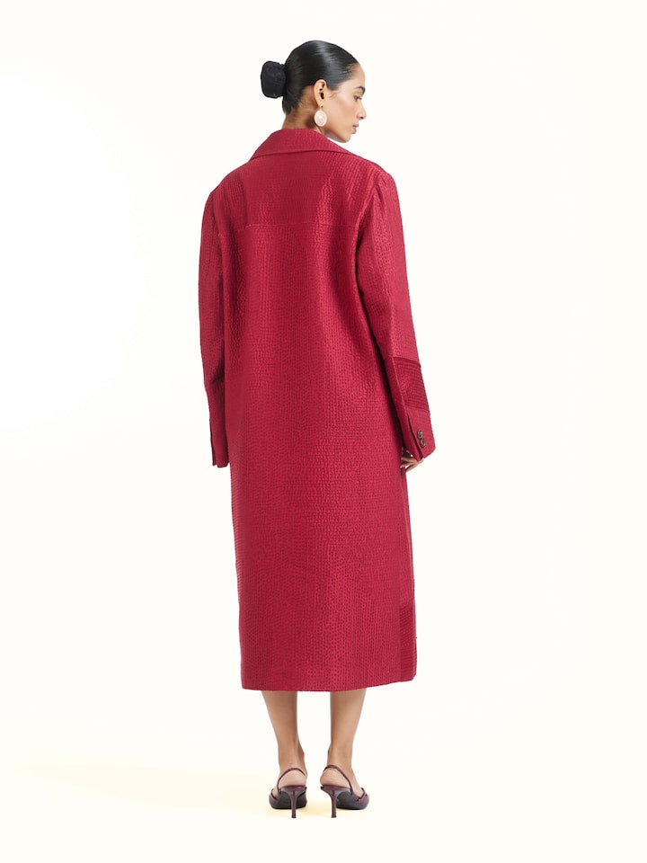 Back view of red silk kantha trench coat displaying overall design and embroidery flow