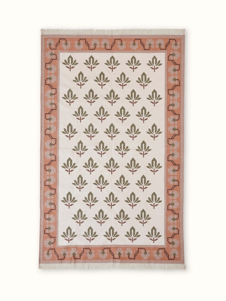Front view of Contemporary lotus blush lawan cotton panja dhurrie, featuring its soft blush color and intricate lotus pattern.