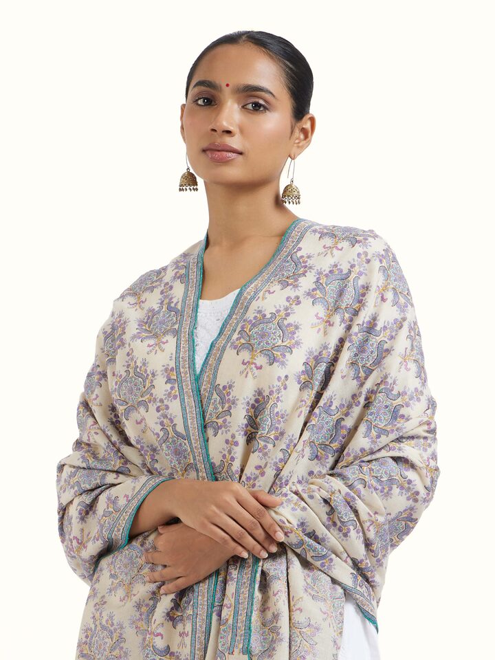 Angled view of Off-white Sozni Hand Embroidered Shawl revealing the depth of its color and intricate pattern