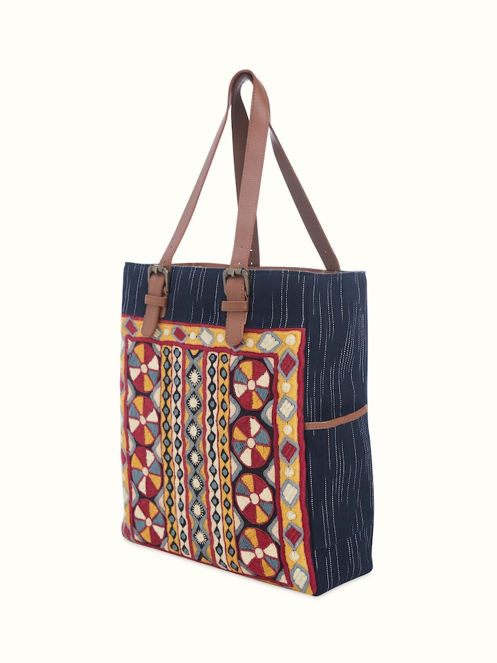 Angled close-up of Grey Leather & Textile Embroidered Tote Bag showing fine textile patterns and leather finish.