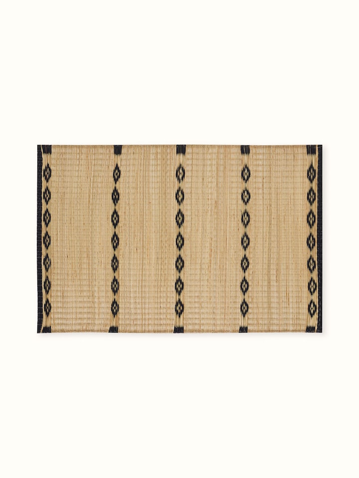 Neatly laid out view of black striped natural Madurkathi table mats from Prakriti