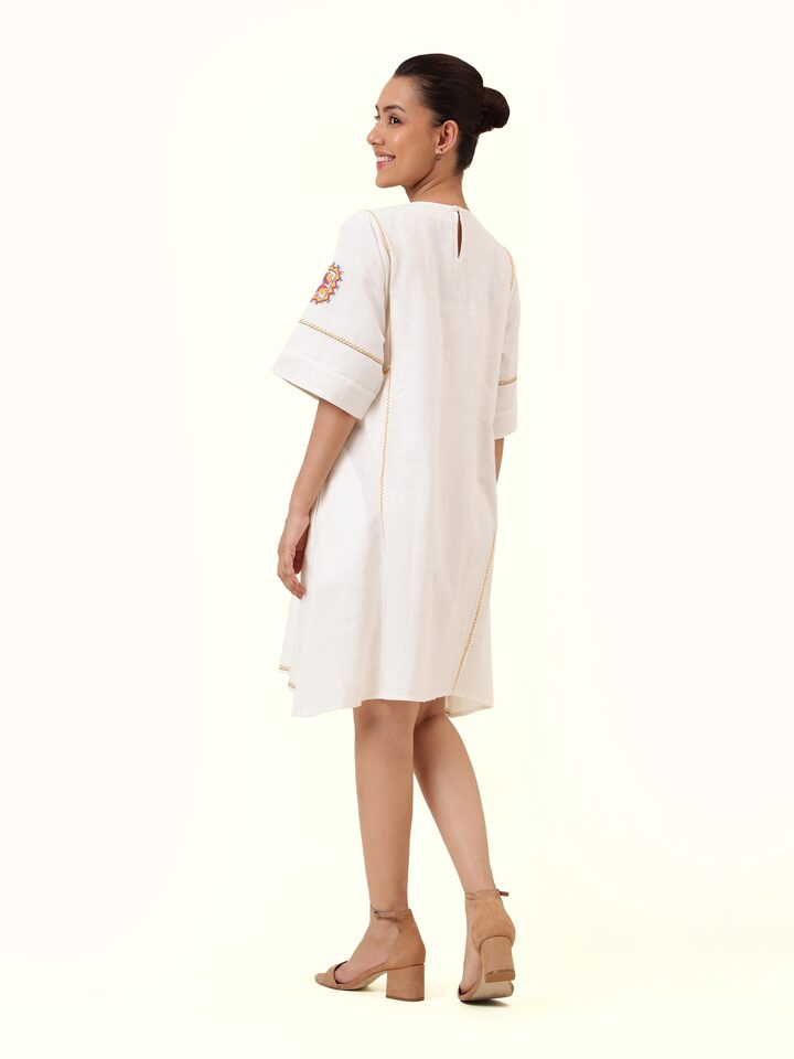Back view of off-white short cotton Rajasthani embroidered dress showing embroidery continuation and dress silhouette.