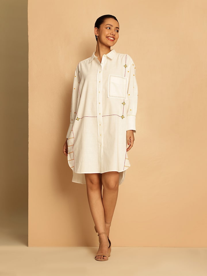 Lifestyle view of off-white embroidered shirt styled with pants, showing intricate detailing.