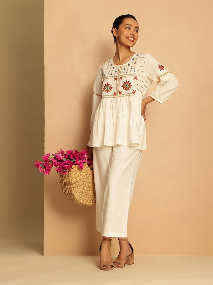 Lifestyle view showing the top paired with printed skirt and silver jewelry.