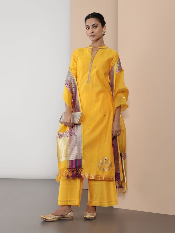 Lifestyle image of yellow Chanderi A-line kurta styled with churidar for a festive ethnic look.