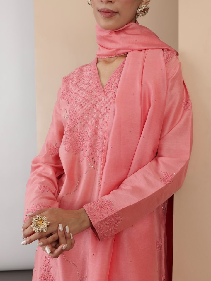 Angled view showing embroidery detail and fabric texture of pink silk kurta set.