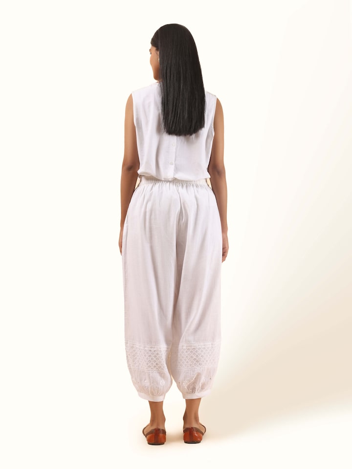 Back view of white cotton chikankari harem pants paired with a casual top, highlighting the flow and fit of the embroidered pants.