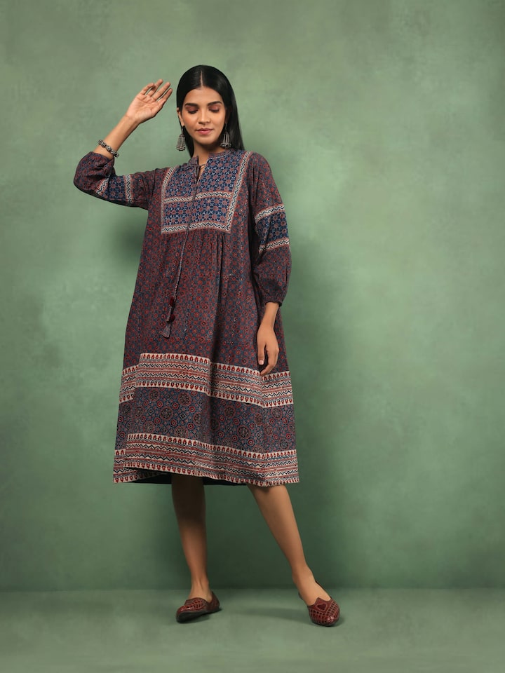 Lifestyle view of model in flowy Ajrakh printed peasant dress with gathered waist