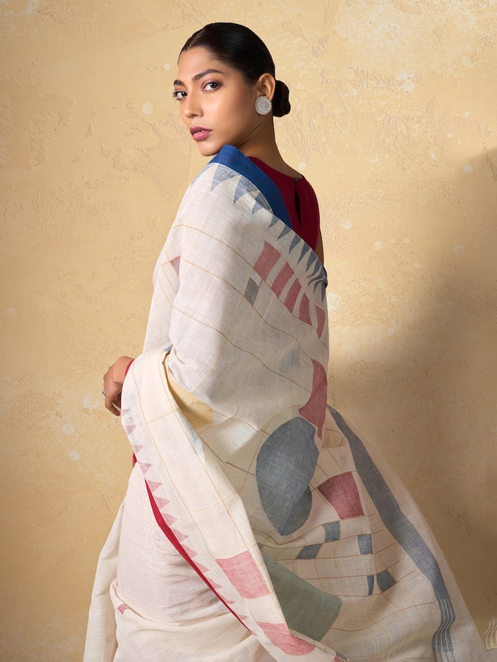 Close-up detail of handwoven Jamdani motifs and cotton threads on white saree