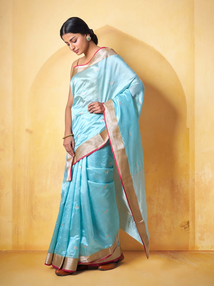 Woman draped in sea blue Chanderi saree, showcasing its graceful fall and refined silk-cotton blend.