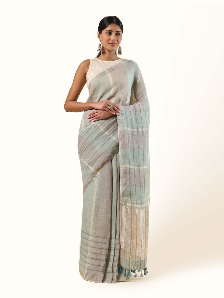 Front view of the light green linen saree accented by delicate Zari threads.