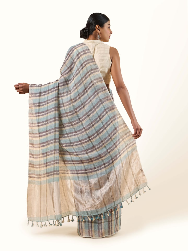 Back view of grey linen Zari saree showcasing the intricate pallu design and flowing silhouette.