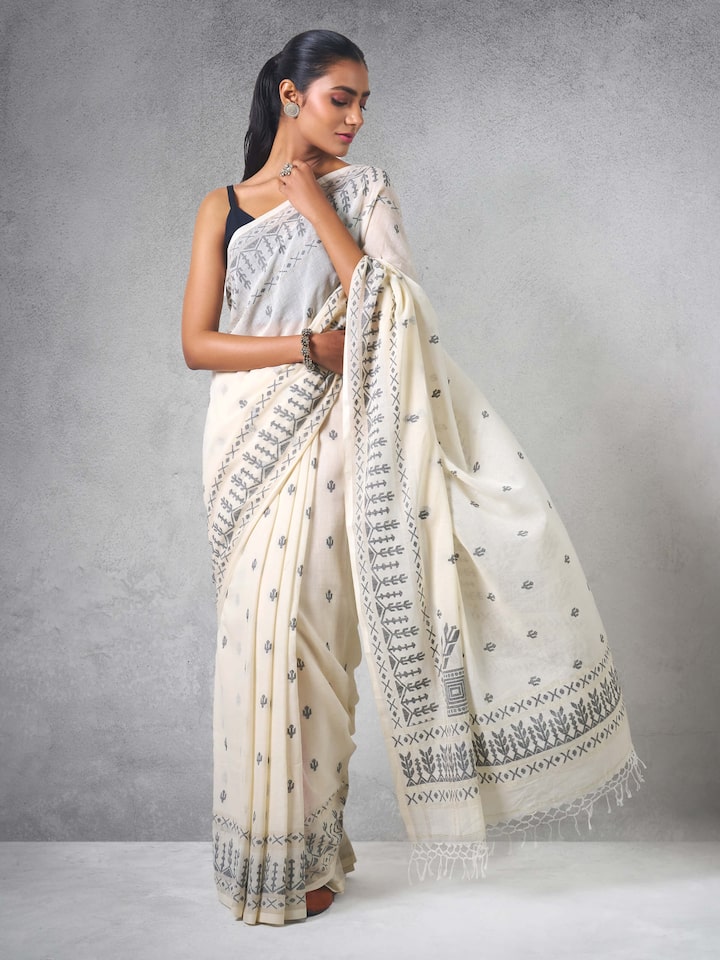 Lifestyle view of off-white cotton Jamdani saree styled with minimal jewelry.