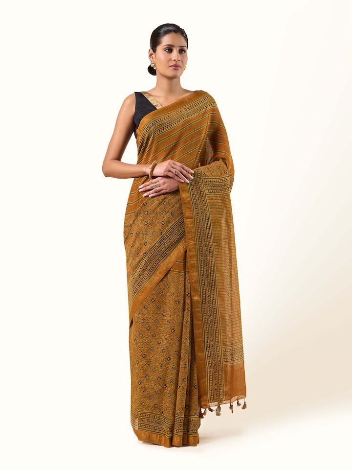 Front view of mustard Maheshwari Ajrakh saree with hand-block floral patterns.