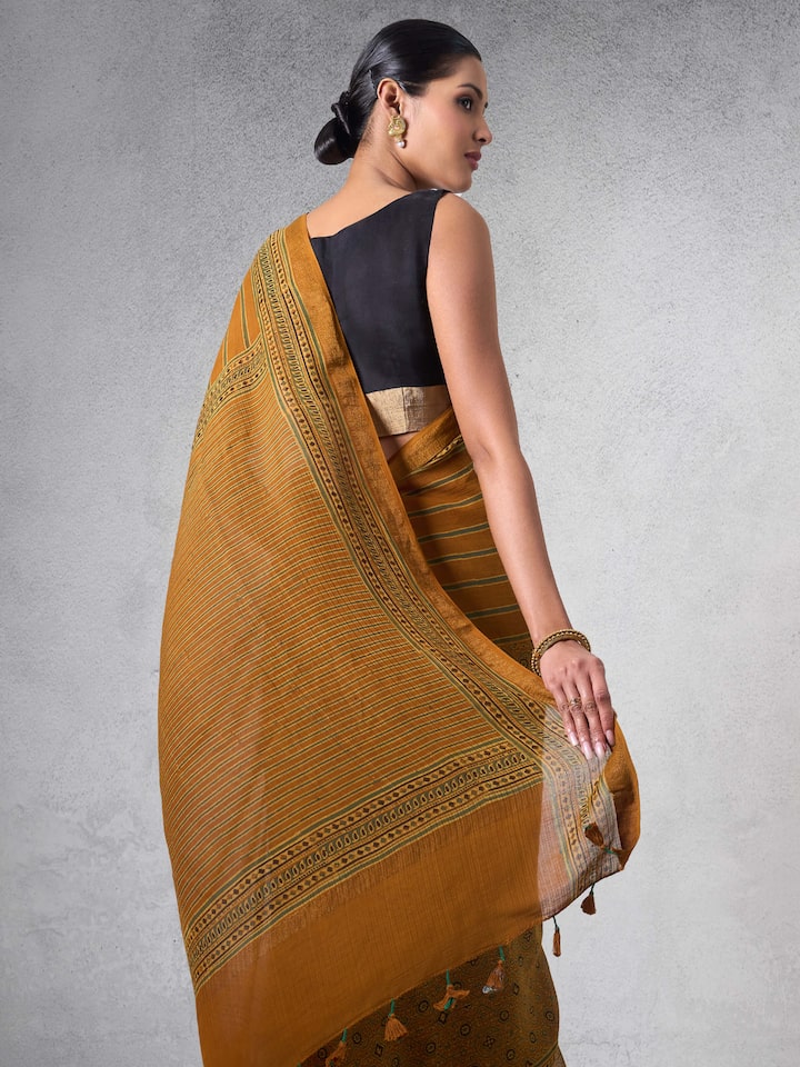 Angled view showcasing drape, zari border, and Ajrakh motifs.