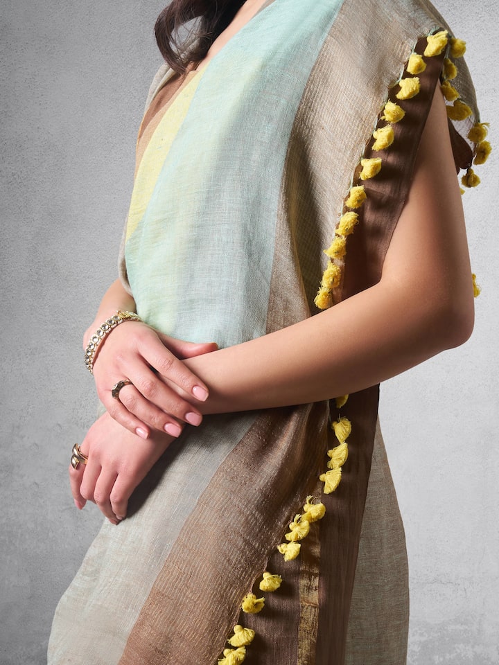 Close-up of linen cotton weave and saree border detail in beige saree.