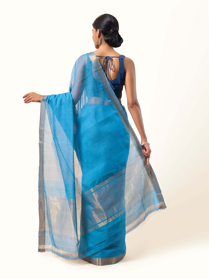 Back view of blue and gold Mangalgiri cotton saree revealing the smooth pleats and contrast border.