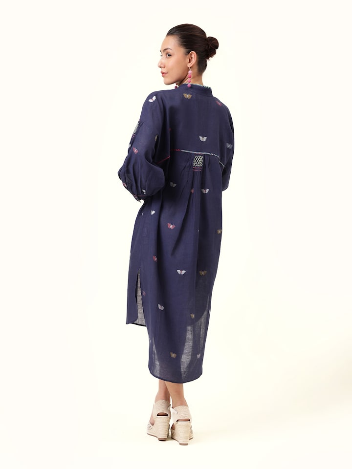 Back view focusing on the flowy cut and unique blend of traditional weaving with modern styling.