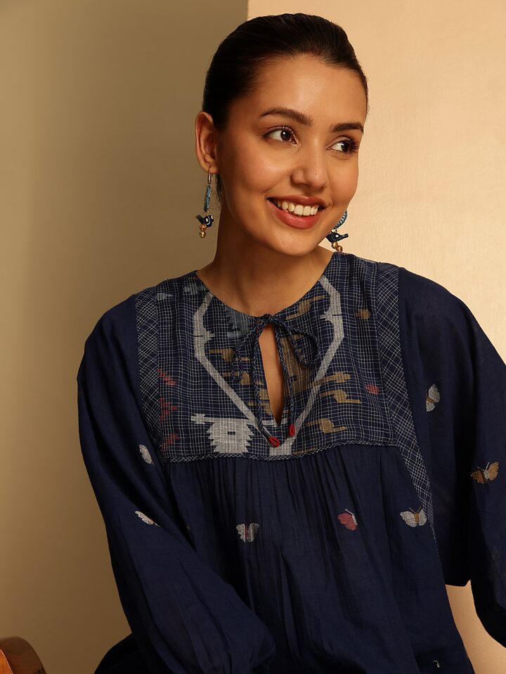 Side angle of blue cotton bohemian top highlighting fine Jamdani weaving details.