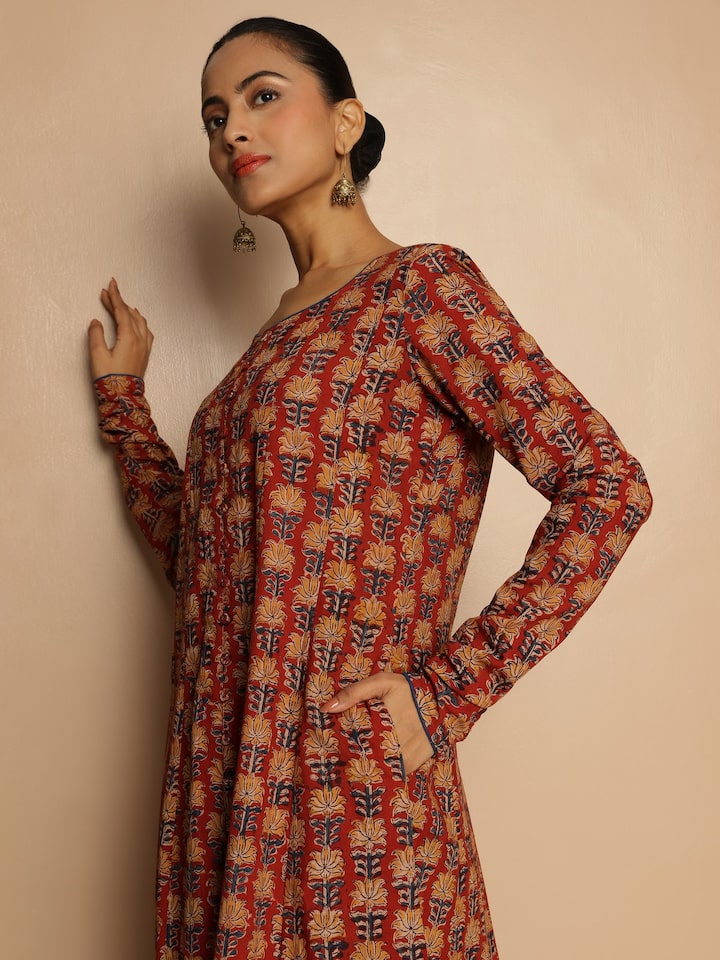 Alternate lifestyle view of red block printed Kalamkari kurta from a festive setup
