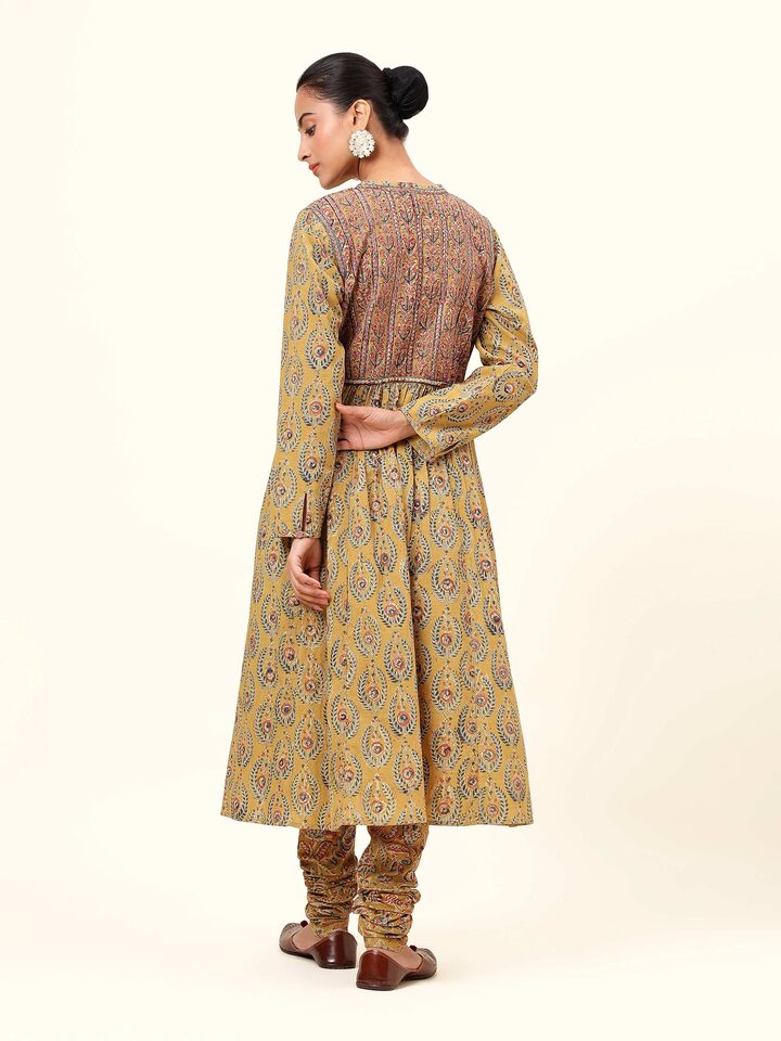 Back view of the yellow cotton Kalamkari kurta showcasing intricate block printing on a flowy fabric.