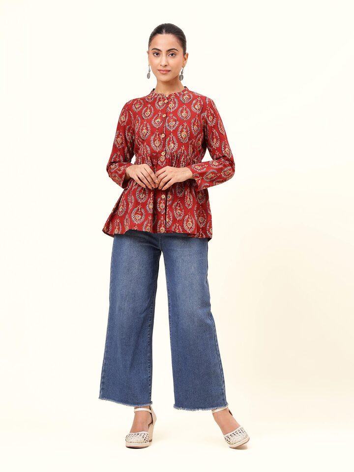 Front view of red cotton Kalamkari block printed peplum top with flared hem and traditional motifs.