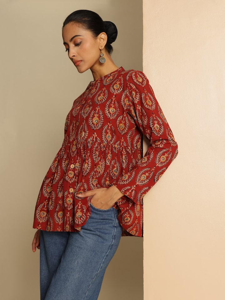 Side view of model in red Kalamkari block printed cotton peplum top showcasing the side flare.