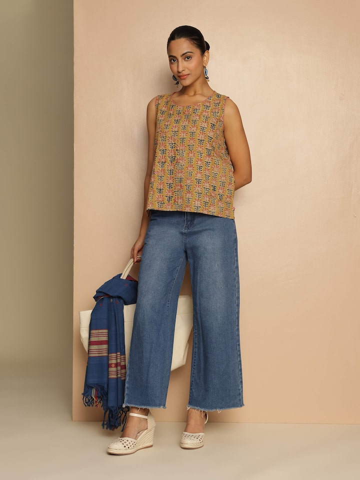 Lifestyle view of yellow cotton Kalamkari block printed top styled with minimal accessories
