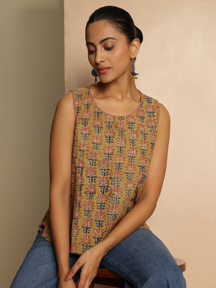 Alternate lifestyle angle of yellow Kalamkari block printed cotton top paired with denim