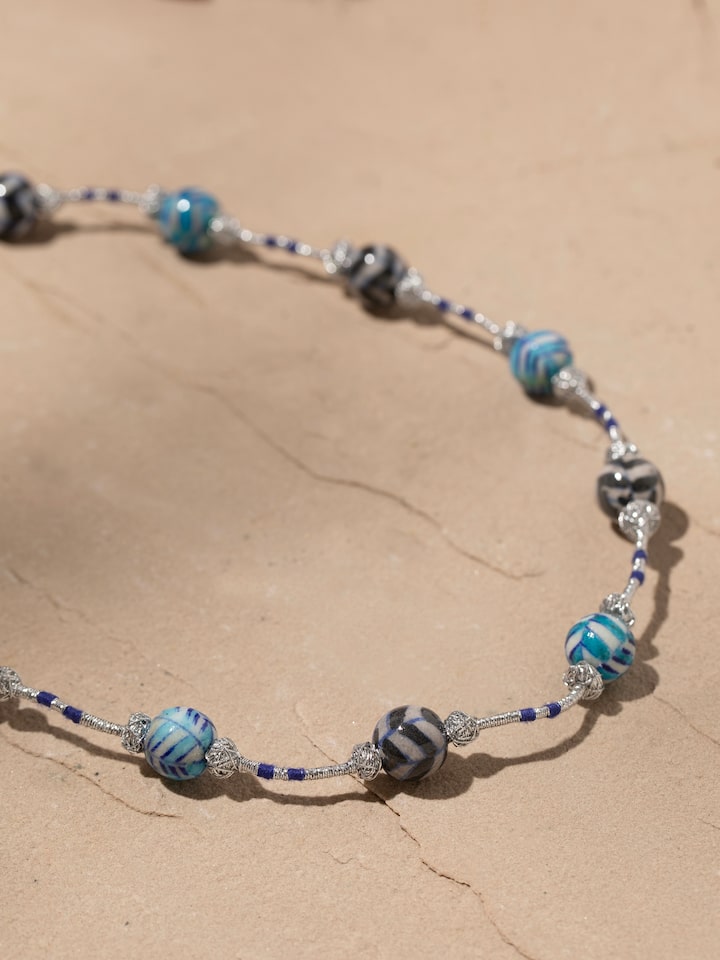 Back view of blue pottery long necklace showing the secure clasp and design details.