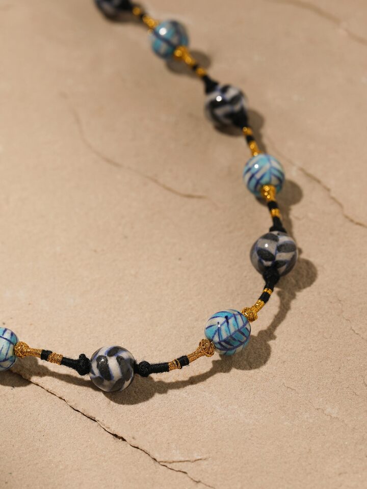 Back view of blue pottery long necklace showing the clasp and overall design.