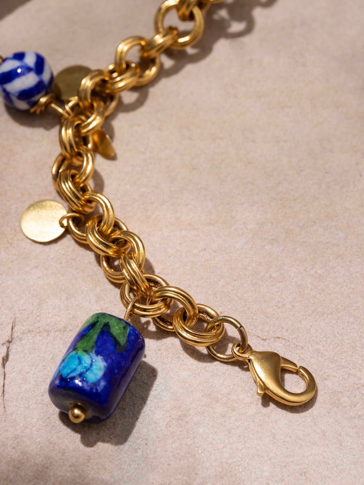 Angled view of blue pottery pendant and chain displaying its elegant design and artistry