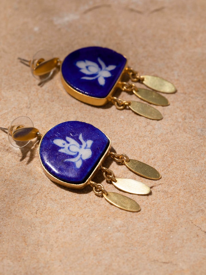 Detailed close-up of blue pottery drop earrings emphasizing the texture and intricate designs.