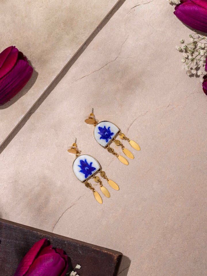 Close-up view of blue pottery drop earrings emphasizing the intricate pottery work and colors.