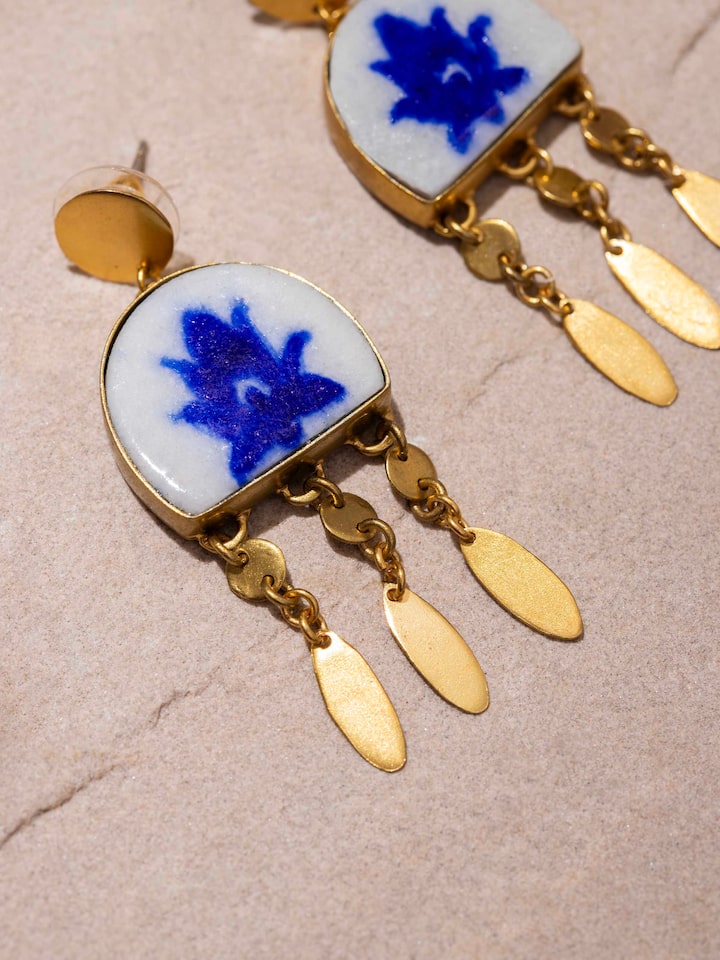 Overhead view of blue pottery drop earrings showing their complete design and hanging style.