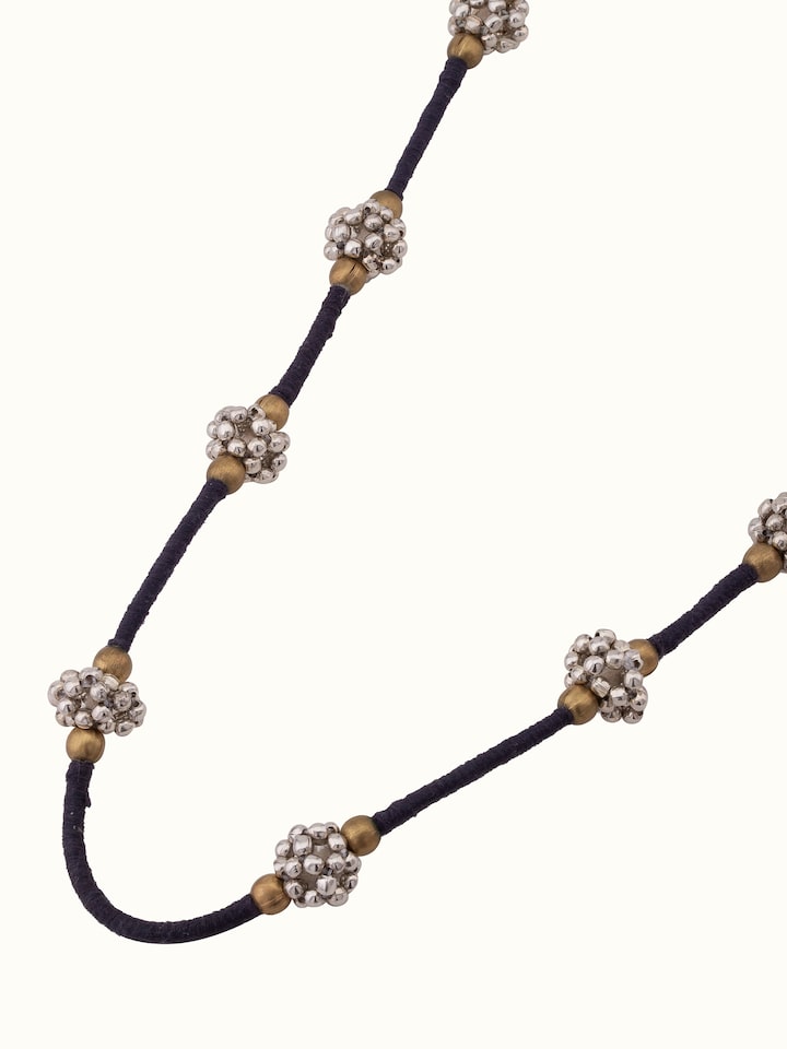 Overhead view of Lambani long necklace displaying its full length and elaborate design.