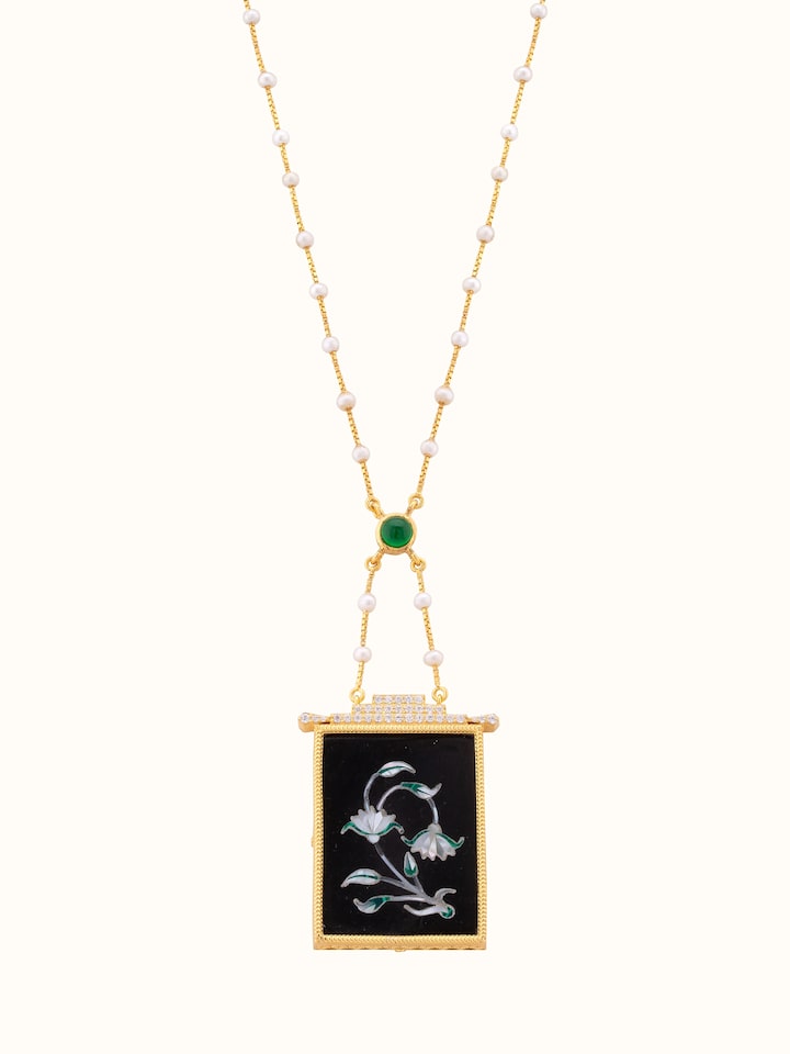 Front view of Pacchikari silver pendant and chain featuring intricate silverwork and a classic design.